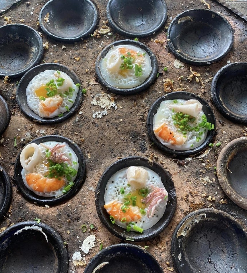 Banh can banh xeo hai san - dac san Phan Thiet nuong trong khuon dat voi tom muc an kem nuoc cham va trung cut mon ngon duong pho
