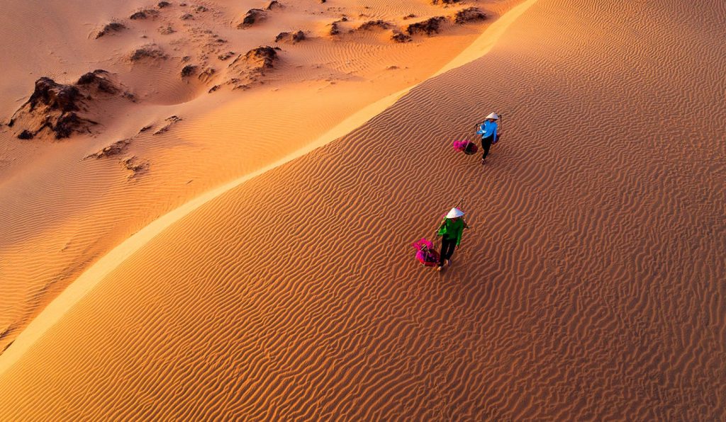 Ve dep Doi cat bay - dac san Phan Thiet, hai nguoi phu nu doi non dang di bo tren cat vang